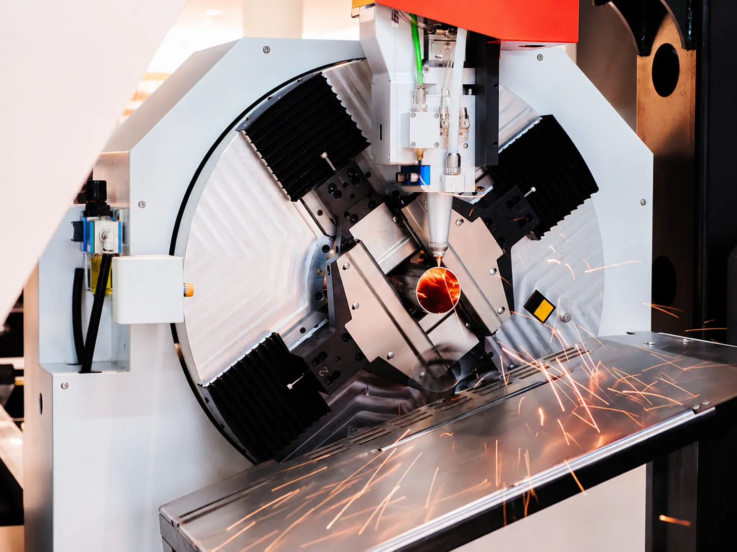 Multi-axis machining center cutting a metal part with sparks
