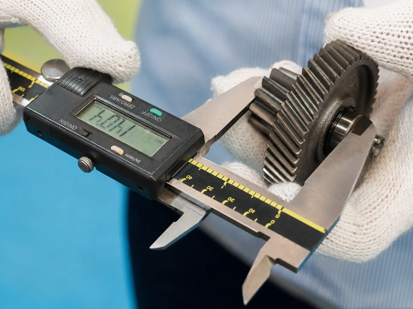 Digital caliper measuring a machined gear