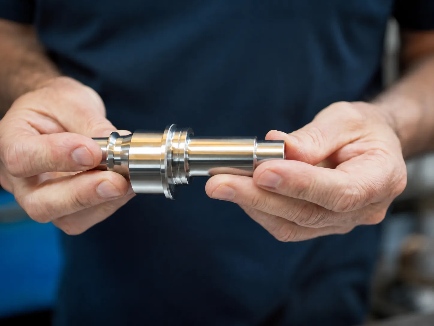 Machinist inspecting a precision-turned metal component
